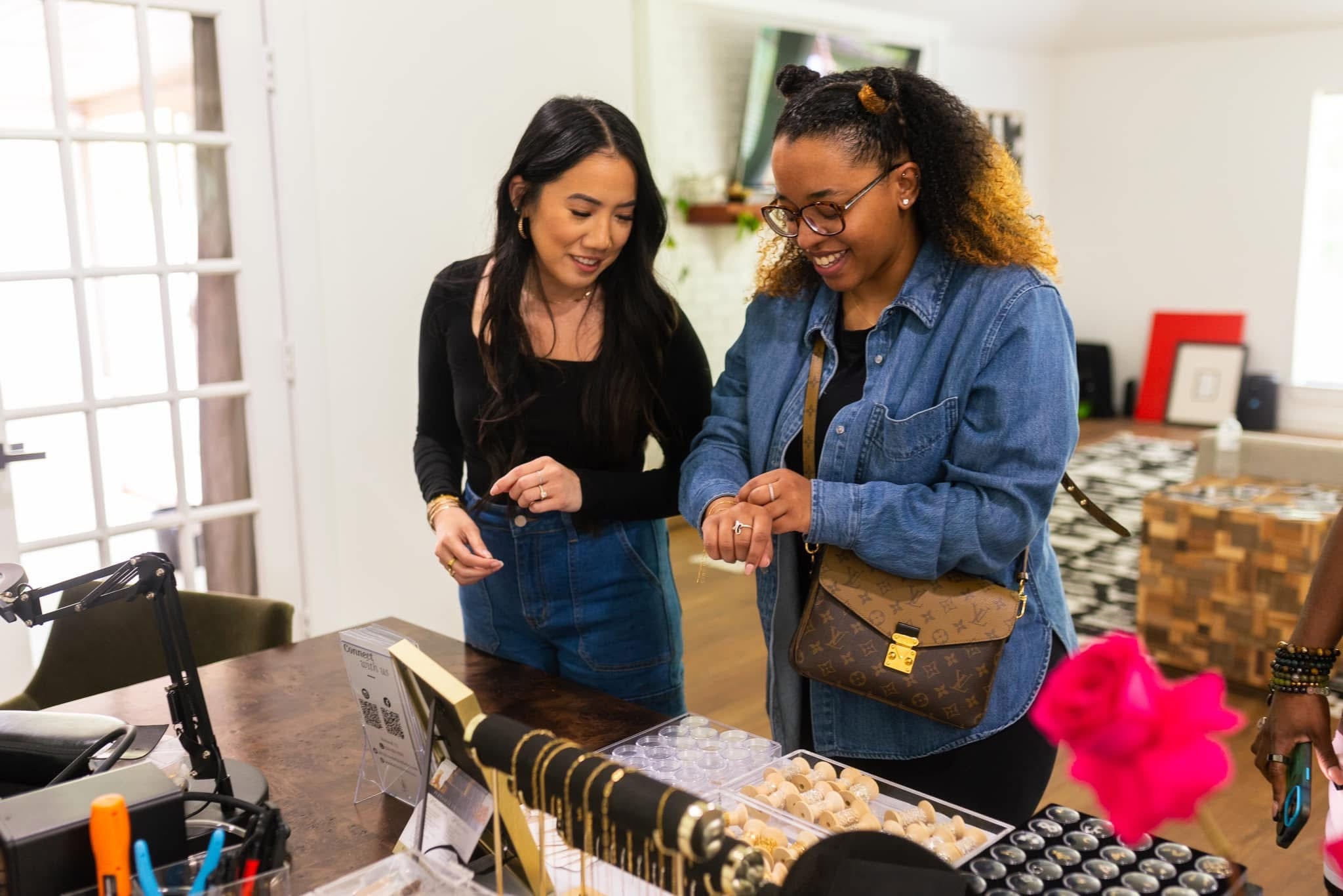 Two women looking at jewelry at private event
